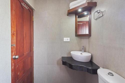 a bathroom with a sink and a toilet and a mirror at Hotel Mart View in Cochin