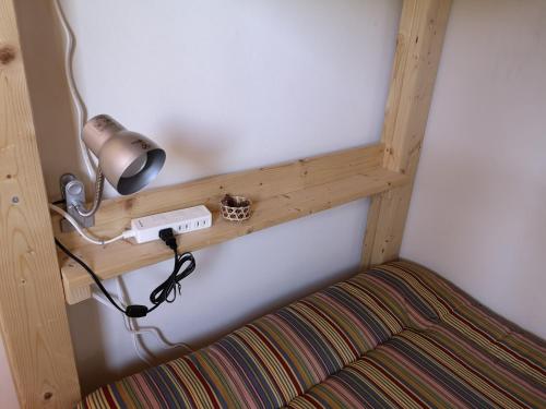 a wooden shelf on a wall with a lamp at 古民家ゲストハウスひまわり in Isa