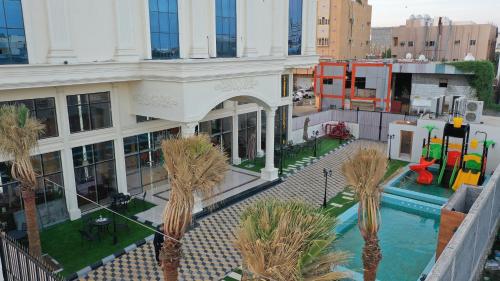 an aerial view of a building with a pool and palm trees at نزل خيال للشقق المخدومه in Jazan