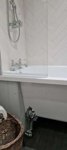 a bathroom with a shower and a sink and a basket at The Family Tree in Whatstandwell