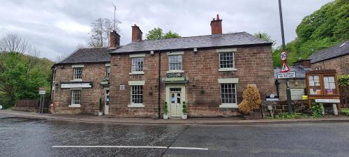 an old brick building on the corner of a street at The Family Tree in Whatstandwell