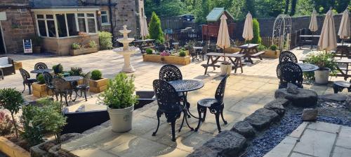 an outdoor patio with tables and chairs and a fountain at The Family Tree in Whatstandwell