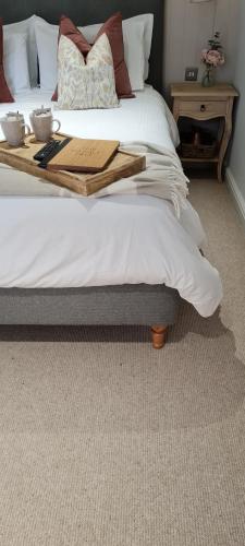 a bedroom with a bed with a wooden tray on it at The Family Tree in Whatstandwell