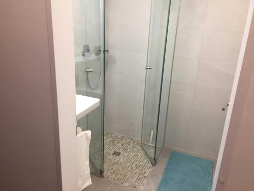 a shower with a glass door next to a sink at Ferienwohnung Jagdhof Spitzingsee in Schliersee