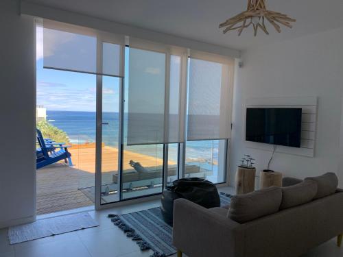 a living room with a couch and a view of the ocean at Villa Mar - Maia in Maia