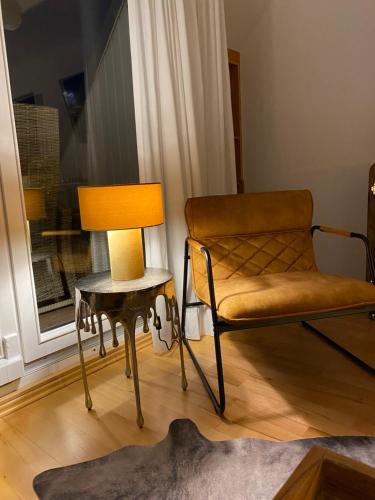 a chair and a lamp in a room with a window at Inspiration Maisonette in Scharbeutz