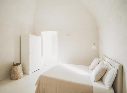 a white bedroom with a bed and a window at Casa Pinta Rooms in Vieste