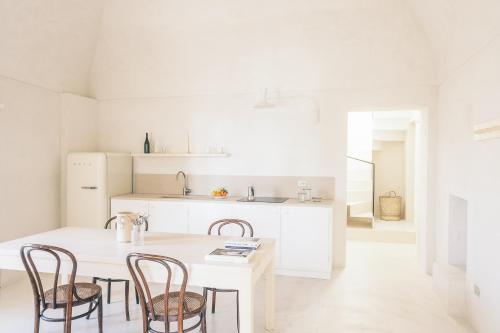 een witte keuken met een tafel en stoelen bij Casa Pinta Rooms in Vieste