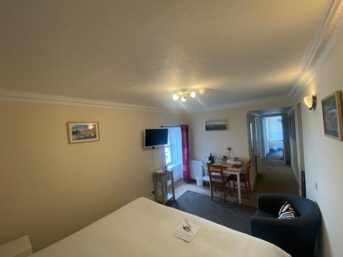 a room with a bed and a table and a dining room at The Bowmore House Bed and Breakfast in Bowmore