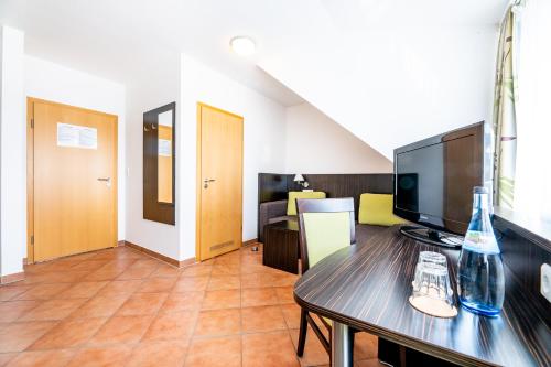 a living room with a television and a table at My Airport Hotel STUTTGART-AIRPORT-MESSE in Leinfelden-Echterdingen