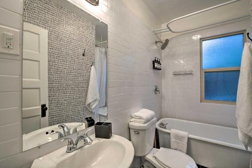 a white bathroom with a sink and a tub and a toilet at Modernized SLC Duplex with Yard about 4 Mi to Dtwn! in Salt Lake City