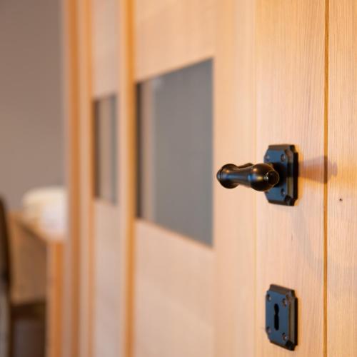 a close up of a wooden door with a knob at Oud Gemeentehuis in Poelkapelle