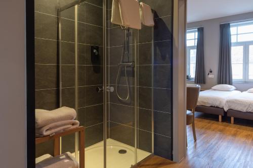 a bathroom with a shower with a glass door at Oud Gemeentehuis in Poelkapelle