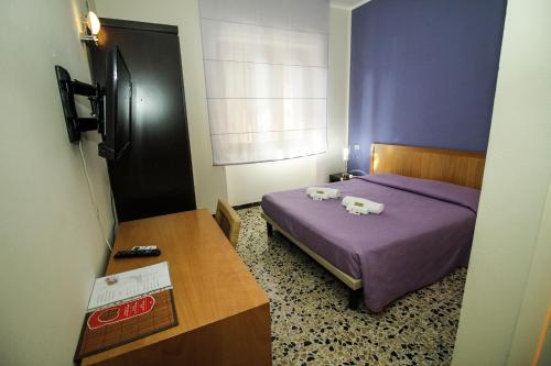 a bedroom with a bed with two towels on it at Hotel I Colori in SantʼAntìoco