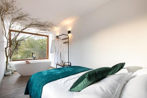 a bedroom with a bed and a bath tub and a window at Mini Rural in Canyelles