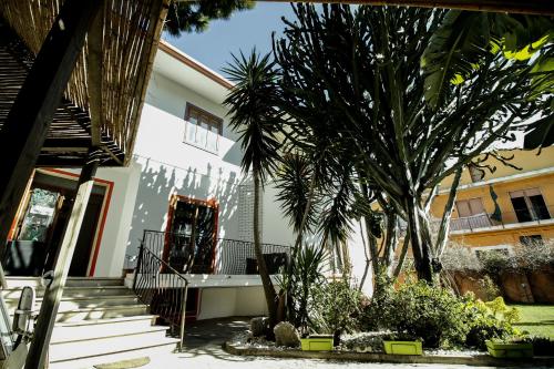 a house with palm trees in front of it at Hotel I Colori in SantʼAntìoco