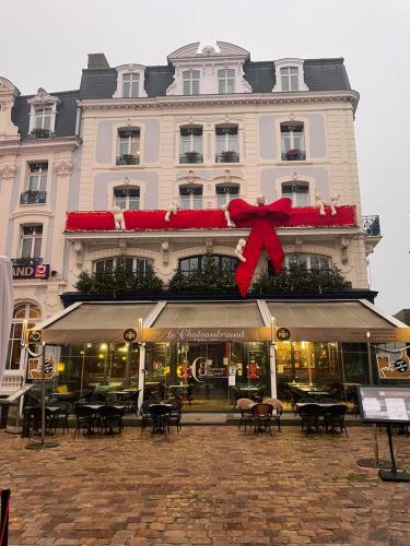 a large building with a large red bow on it at Hôtel France et Chateaubriand in Saint Malo