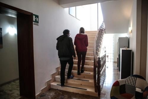 two people walking down stairs in a building at Hotel I Colori in SantʼAntìoco