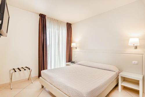 a white room with a bed and a window at Hotel & Residence Exclusive in Marina di Carrara