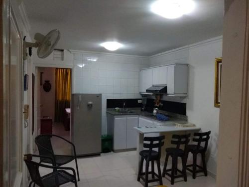 eine Küche mit Stühlen, einem Tisch und einem Kühlschrank in der Unterkunft Acogedor apartamento a 15 metros del mar in Santa Marta