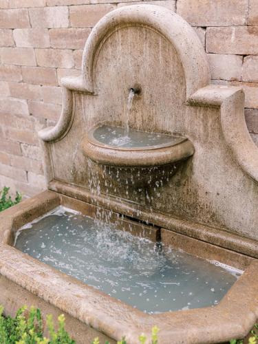 a stone water fountain in front of a brick wall at Fairville Inn in Chadds Ford