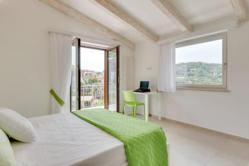 Habitación blanca con cama, escritorio y ventanas en LeMoon Holiday Home x7 con Terrazzo e Parcheggio, en Massa Lubrense