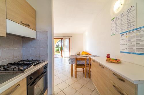 cocina con fogones horno superior junto a una mesa en ISS Travel, L'Uddastru Panoramic Apartments - with private outdoor terrace, en San Teodoro