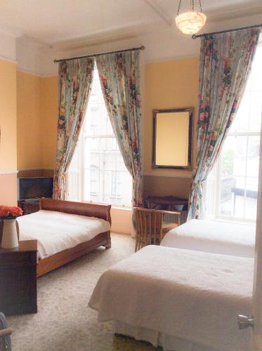 a bedroom with two beds and a large window at Harveys Guest House in Dublin