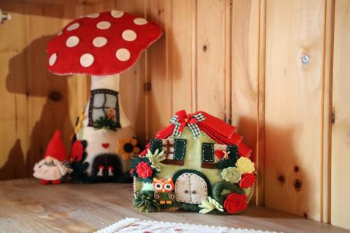 a small house with a red hat next to a mushroom at Baita Medil in Predazzo