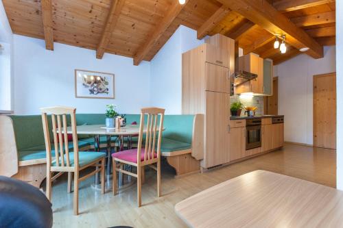 a kitchen and dining room with a table and chairs at Gästehaus Dreier in Neukirchen am Großvenediger