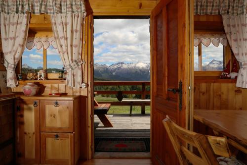 a door to a kitchen with a view of mountains at Baita Medil in Predazzo