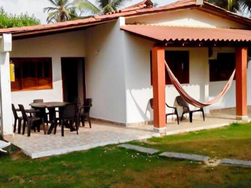 ein Haus mit einer Terrasse mit einem Tisch und Stühlen in der Unterkunft Cabañitas del Mar by Rotamundos in Coveñas