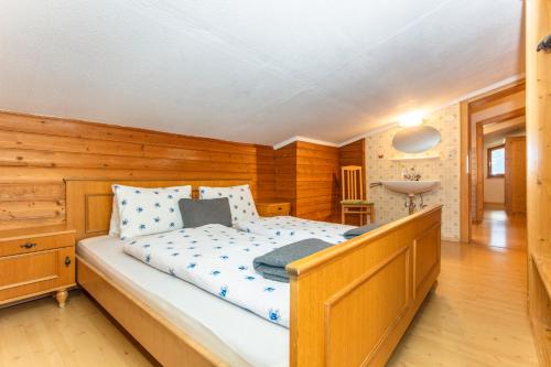 a bedroom with a bed and a wooden wall at Gästehaus Dreier in Neukirchen am Großvenediger