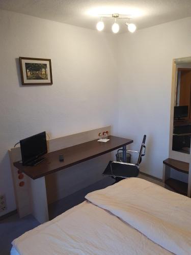 a hotel room with a desk and a bed at Pension Stettiner Hof in Eggesin