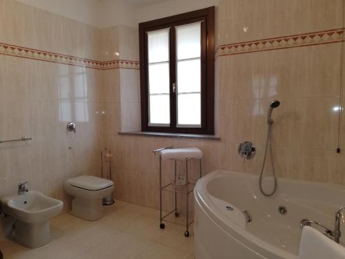 ein Badezimmer mit einer Badewanne, einem WC und einem Waschbecken in der Unterkunft La Foresteria dei Baldi in Pavia