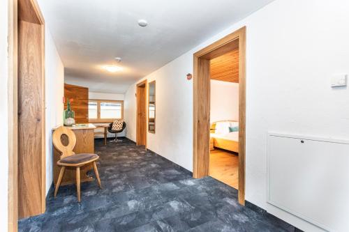 a hallway with a room with a bed and a chair at Gästehaus Dreier in Neukirchen am Großvenediger