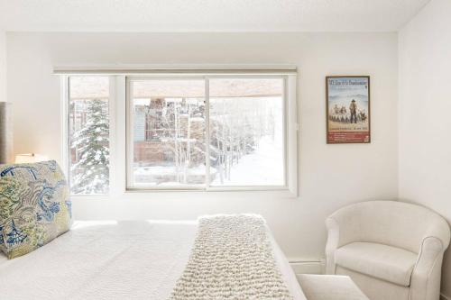 a bedroom with a bed and a chair and a window at 700 Monarch 301 in Aspen