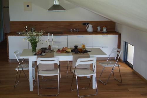 cocina con mesa blanca y sillas en Apartments Lom, en Most na Soči
