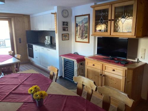 a kitchen with a table and a dining room at Ferienwohnungen Rieser in Hainzenberg