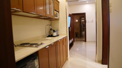 a kitchen with wooden cabinets and a counter top at نزل خيال للشقق المخدومه in Jazan