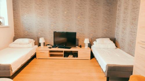 a living room with two beds and a television at Apartamet 45 in Płock