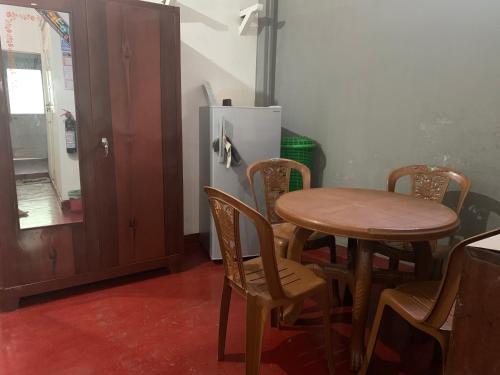 a kitchen with a table and chairs and a refrigerator at Sobha Holiday Home in Anuradhapura