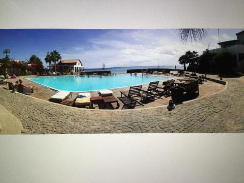 a large swimming pool with chaise lounges and chairs at Apt14 Porto Antigo 1 with Pool and Beach views in Santa Maria