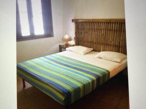 a bedroom with a bed with a striped blanket at Apt14 Porto Antigo 1 with Pool and Beach views in Santa Maria