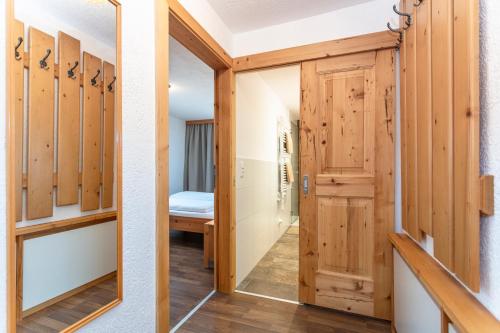 a dressing room with wooden doors and a mirror at Gästehaus Dreier in Neukirchen am Großvenediger