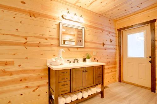 La salle de bains est pourvue d'un lavabo et d'un miroir. dans l'établissement Lazy Raccoon Cabin, à Starkeytown