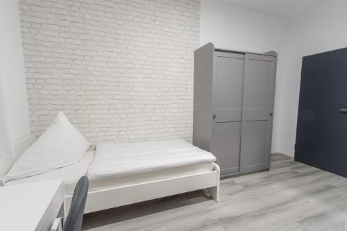 a white room with a bed and a cabinet at Hotel Billard Center Weywiesen in Bottrop