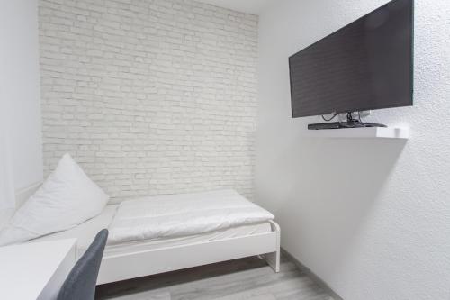 een kamer met een bed en een tv aan de muur bij Hotel Billard Center Weywiesen in Bottrop