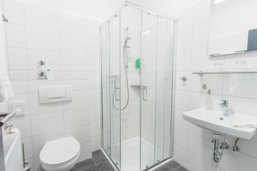 a bathroom with a shower and a toilet and a sink at Hotel Billard Center Weywiesen in Bottrop