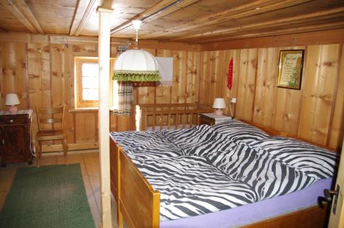 ein Bett mit Zebramuster in einem Holzzimmer in der Unterkunft Ferienhaus Brün in Valendas